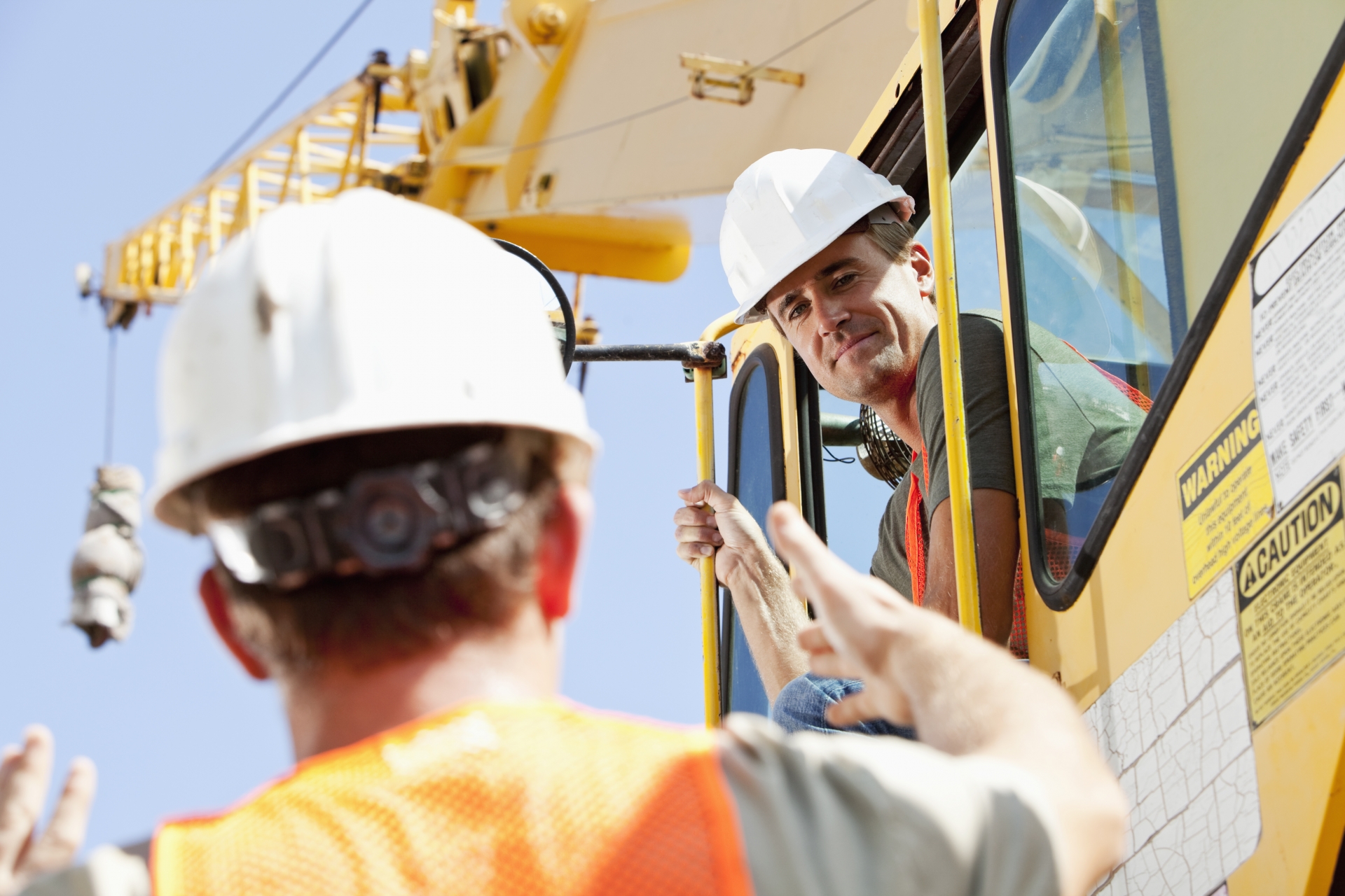 Construction worker talking to crane operator